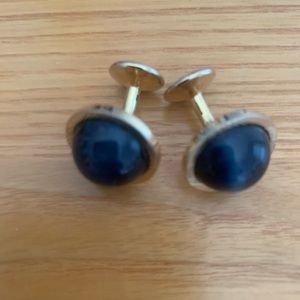 Cufflinks round gold with navy stone.